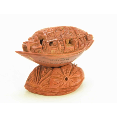 288 - A Chinese nut boat sculpture on stand, intricately carved with passengers looking out, the underside... 