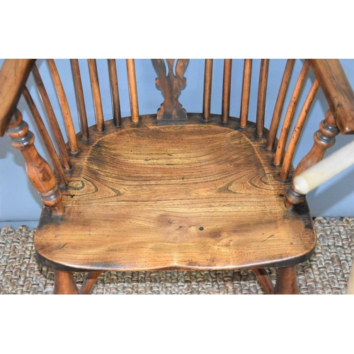 491 - A yew and elm wood Windsor chair with bent wood top-rail and arm rests, linked by a pierced splat an... 