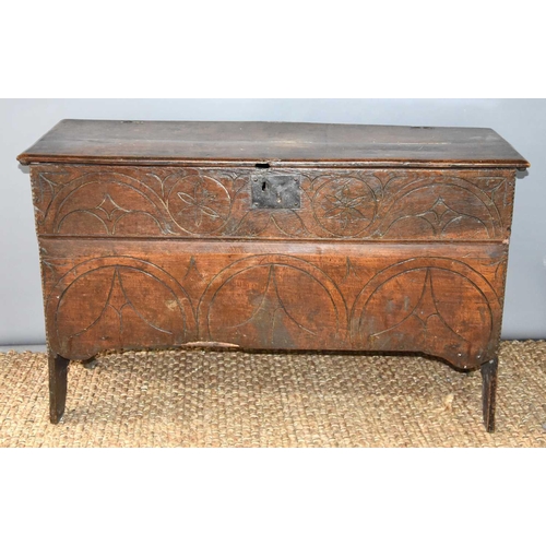 510 - A 17th century boarded oak coffer with candle box and carving to the front.