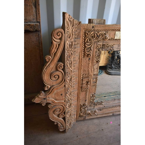 512 - A large wooden window frame, made into a mirror, with a twin scroll pediment, 116cms tall by 110cms ... 