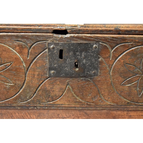 510 - A 17th century boarded oak coffer with candle box and carving to the front.