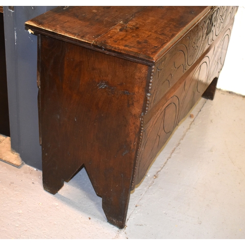 510 - A 17th century boarded oak coffer with candle box and carving to the front.