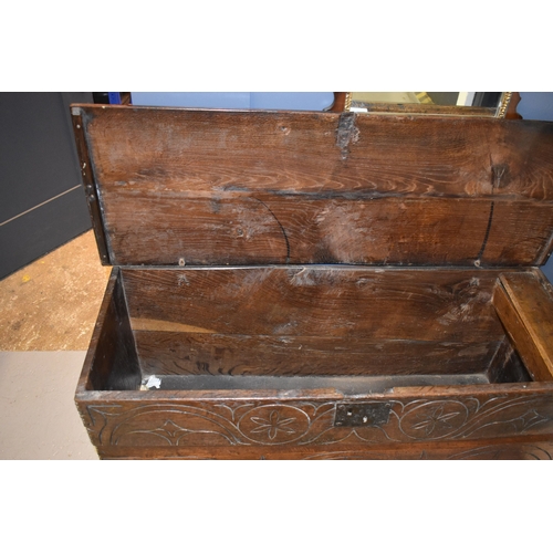 510 - A 17th century boarded oak coffer with candle box and carving to the front.