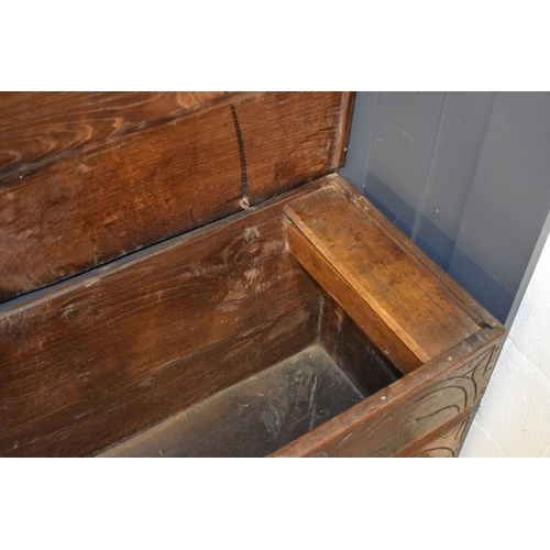 510 - A 17th century boarded oak coffer with candle box and carving to the front.