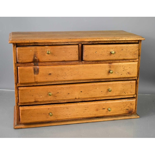 145 - An antique pine collectors cabinet / apprentice piece chest of two over three long drawers with bras... 