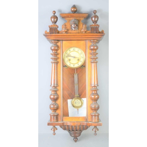 15 - A late 19th century mahogany cased Vienna style wall clock with half turned pillars, 89cms tall