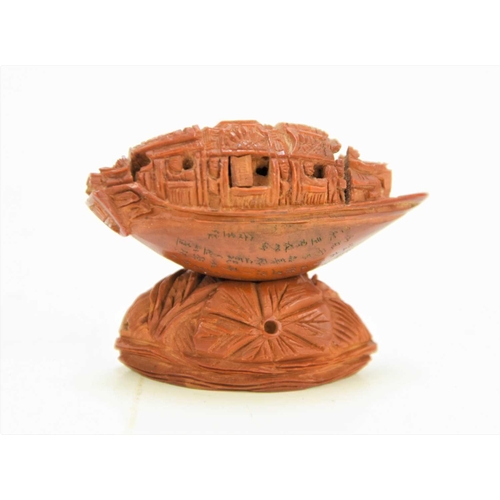 288 - A Chinese nut boat sculpture on stand, intricately carved with passengers looking out, the underside... 