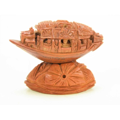 288 - A Chinese nut boat sculpture on stand, intricately carved with passengers looking out, the underside... 