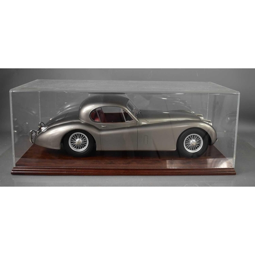 376 - A model silver Jaguar, with numberplate JAG120, in a perspex case.