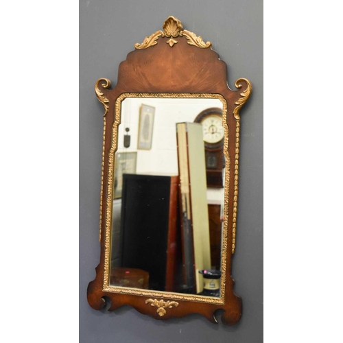 411 - A reproduction mahogany and gold painted wall mirror, with shell and foliate scroll carved detailing... 