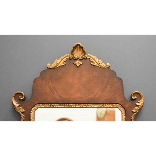 411 - A reproduction mahogany and gold painted wall mirror, with shell and foliate scroll carved detailing... 