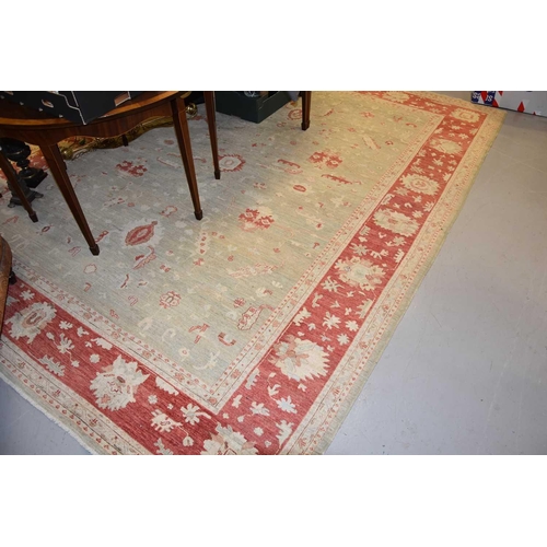 432 - Large pale green and cream rug with deep red details and a wide border, 275cms by 348cms