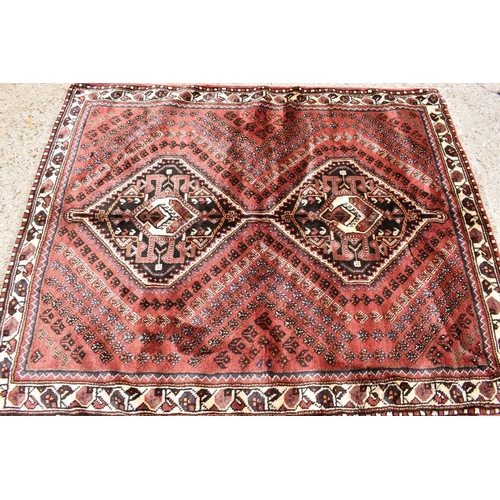 433 - A Persian wool rug with red / brown ground, hand woven in soft pile, the centre with decorative diam... 