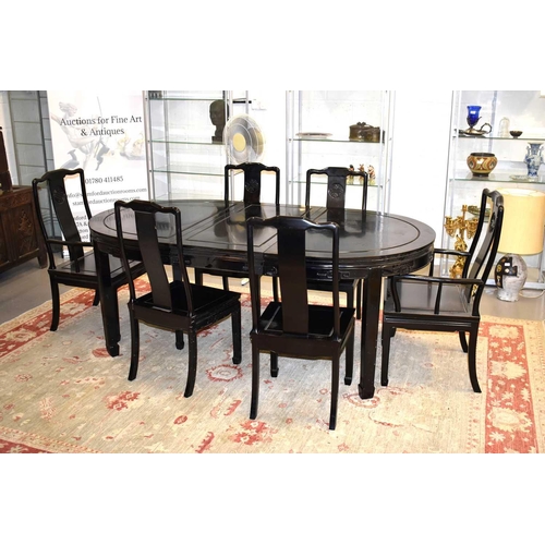 464 - A Chinese black lacquered dining table with four chairs and two carvers.