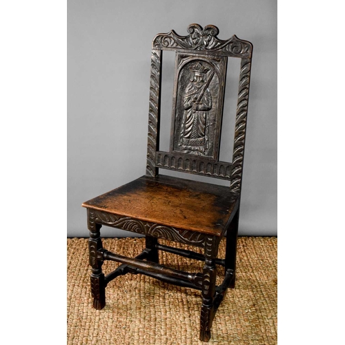 492 - A late 18th/early 19th century hall chair, the back panel carved with a saint.