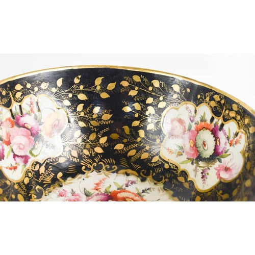 201 - A 19th century black ground bowl, painted with floral cartouches, and highlighted with gilding, 30cm... 