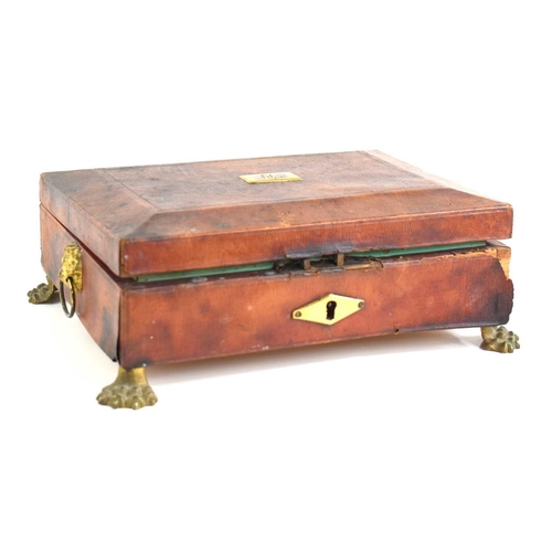 332 - A Regency red leather clad sewing box of sarcophagus form, lion head ringed handles with monogrammed... 