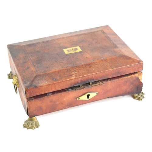 332 - A Regency red leather clad sewing box of sarcophagus form, lion head ringed handles with monogrammed... 