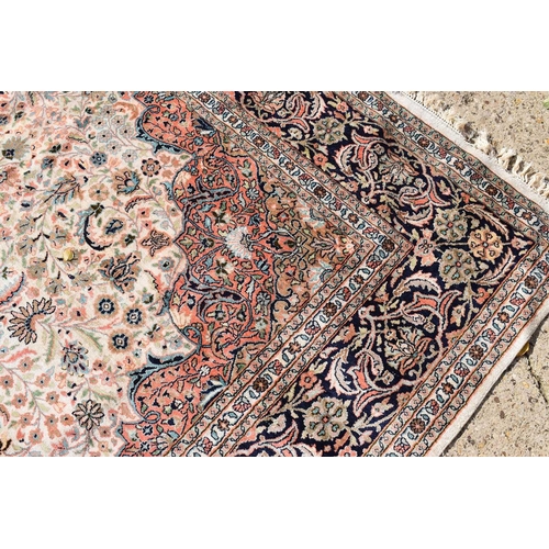 513 - A fine Kashmiri cream ground silk blend rug with foliate decoration throughout, 304cm by 213cm.