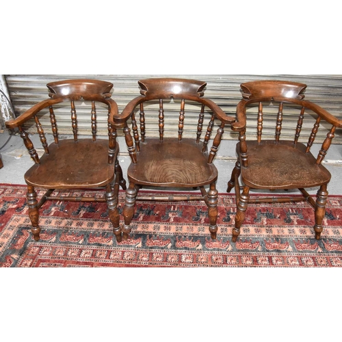 517 - A group of three antique elm Captain's chairs.