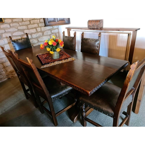 525 - A 17th century style oak trestle table and matching chairs with leather backs and seats, the table m... 