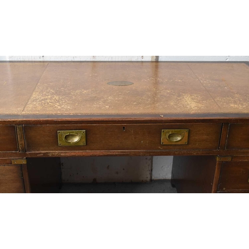 546 - A 20th century campaign style pedestal desk, with brown leather inset writing surface, over an arran... 