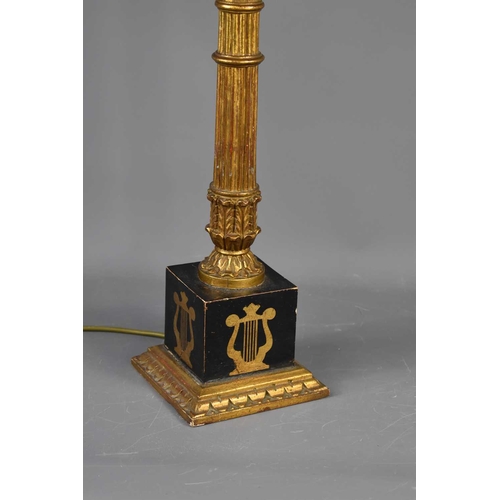 569 - A French Empire style giltwood and ebonised lamp base, the column raised on square plinth painted wi... 