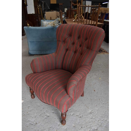 571 - A button back armchair, in newly upholstered striped fabric, raised on mahogany turned legs.