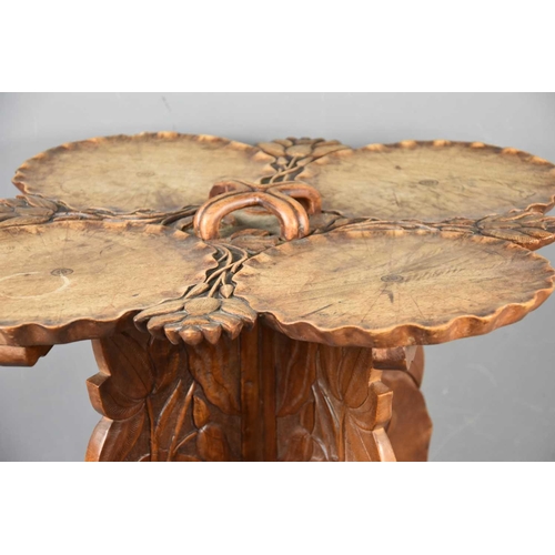 576 - An unusual quatrefoil top table, the top and legs carved with flowers throughout, 45cm high together... 