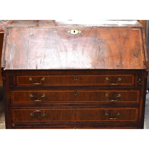 589 - A George III walnut bureau, the fall front enclosing mahogany and satinwood crossbanding interior of... 