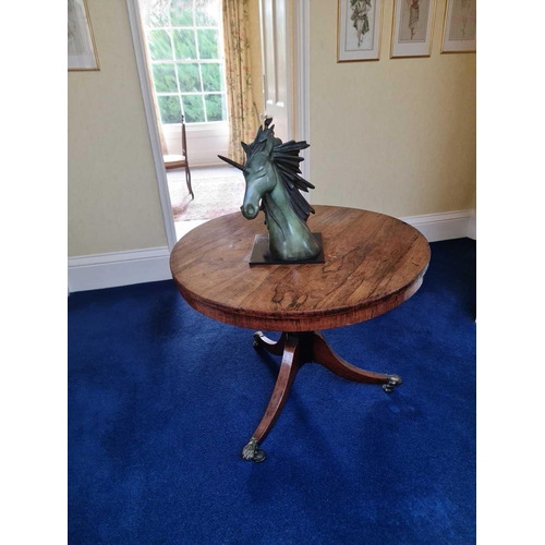 604 - A Regency rosewood breakfast table, the circular top with plain frieze, on turned column and three o... 