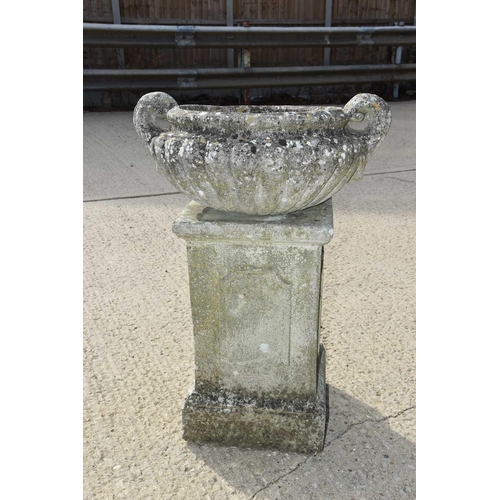 618 - A stone garden urn raised on a rectangular plinth, 100cm high.