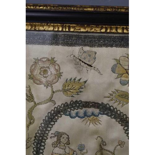 98 - A late Georgian silk embroidered panel depicting a girl holding a flower with dog at her feet in a r... 