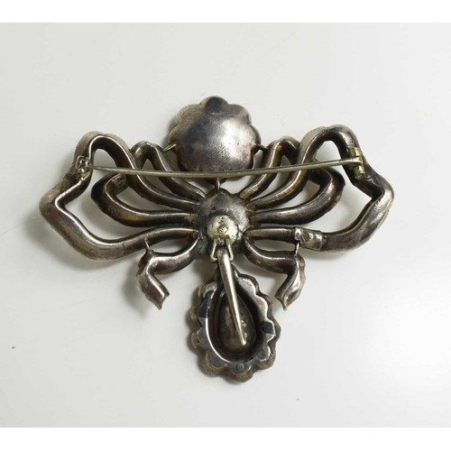 1 - A Georgian silver and yellow gem set metamorphic brooch pendant, in the form of a bow with flower he... 