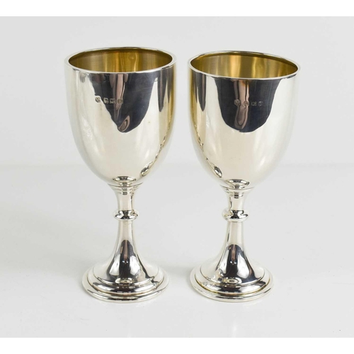 152 - A pair of silver goblets, Birmingham 1935, with residual gilded interiors, one bearing presentation ... 