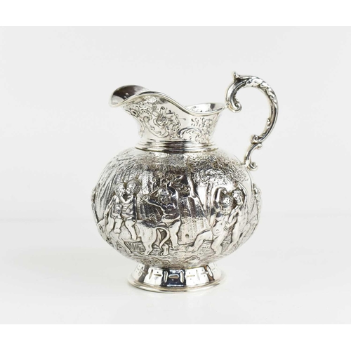 156 - A continental silver jug, embossed with putti in various poses, raised on a footed base, and having ... 