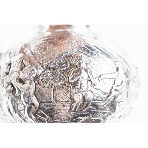 156 - A continental silver jug, embossed with putti in various poses, raised on a footed base, and having ... 