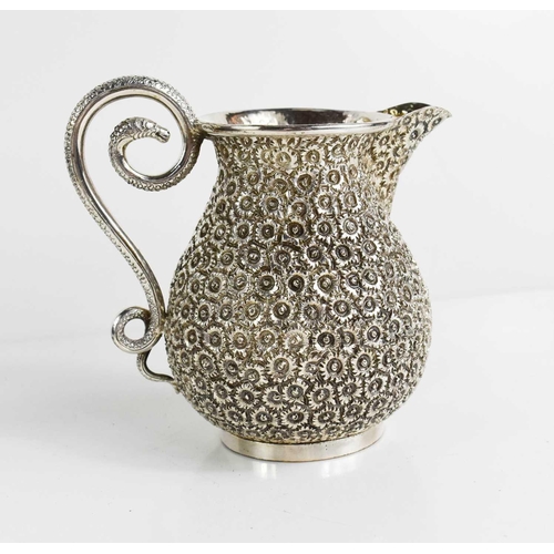 162 - A continental silver jug chased and repoussed with daises, and having a snake form handle, and havin... 