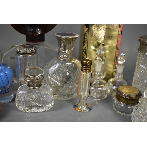 187 - A collection of vintage scent and perfume bottles including a circular cut glass bottle, the silver ... 