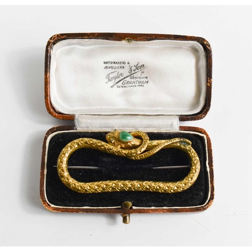 188 - A 19th century gilt metal brooch in the form of a snake, inset with a green coloured cabochon to the... 