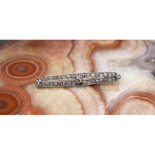 203 - An Art Deco 18ct white gold, platinum, and diamond bar brooch, set with a central diamond approximat... 