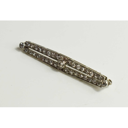 203 - An Art Deco 18ct white gold, platinum, and diamond bar brooch, set with a central diamond approximat... 