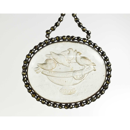 21 - A late Georgian marcasite and pressed glass pendant, depicting birds watering at an urn, with an iri... 