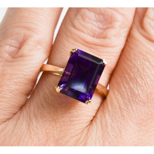 210 - A 9ct gold and amethyst cocktail ring, the emerald cut amethyst in four claw setting, size N, 3.6g.