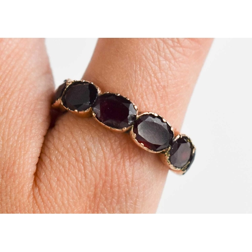 22 - A Georgian rose gold (tested as) and garnet oval set five stone ring, size U/V, 4.9g.