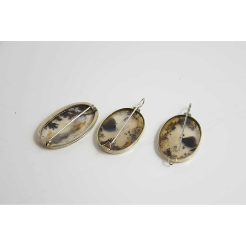 235 - A silver and moss agate oval brooch and matching dress clips, with long posts to the back; secured w... 