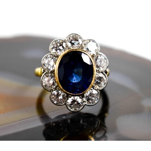 299 - An 18ct yellow gold, sapphire and diamond ring, the central oval cut deep cornflower blue sapphire o... 