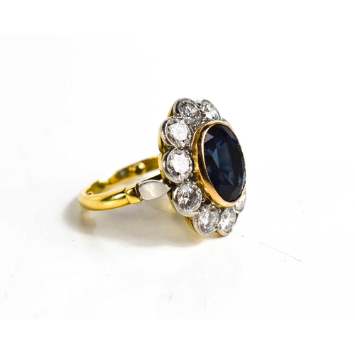 299 - An 18ct yellow gold, sapphire and diamond ring, the central oval cut deep cornflower blue sapphire o... 