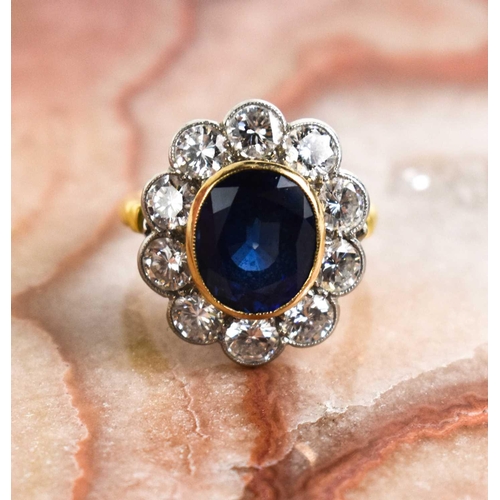 299 - An 18ct yellow gold, sapphire and diamond ring, the central oval cut deep cornflower blue sapphire o... 