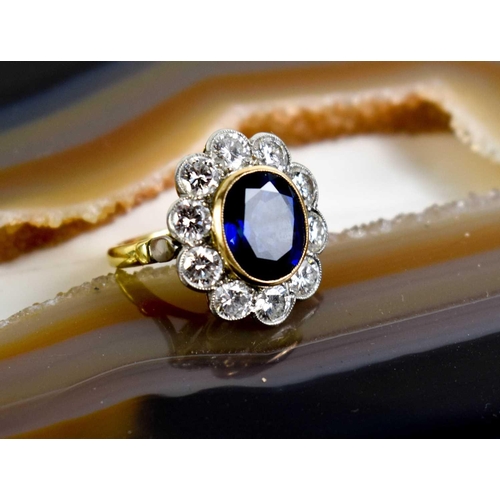 299 - An 18ct yellow gold, sapphire and diamond ring, the central oval cut deep cornflower blue sapphire o... 